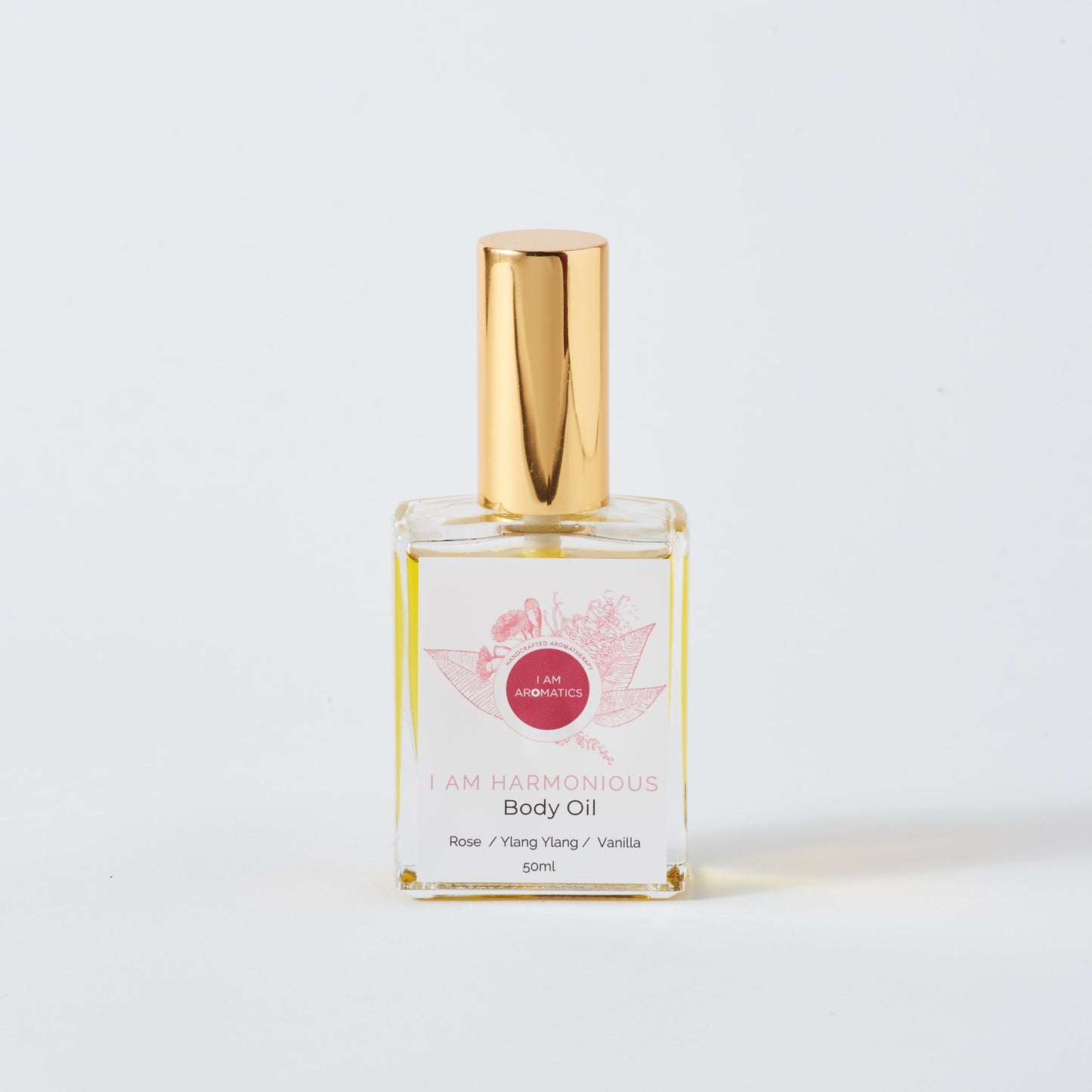 harmonious 50ml body oil, clear glass rectangle bottle with gold atomiser, pink botanical logo and pink font