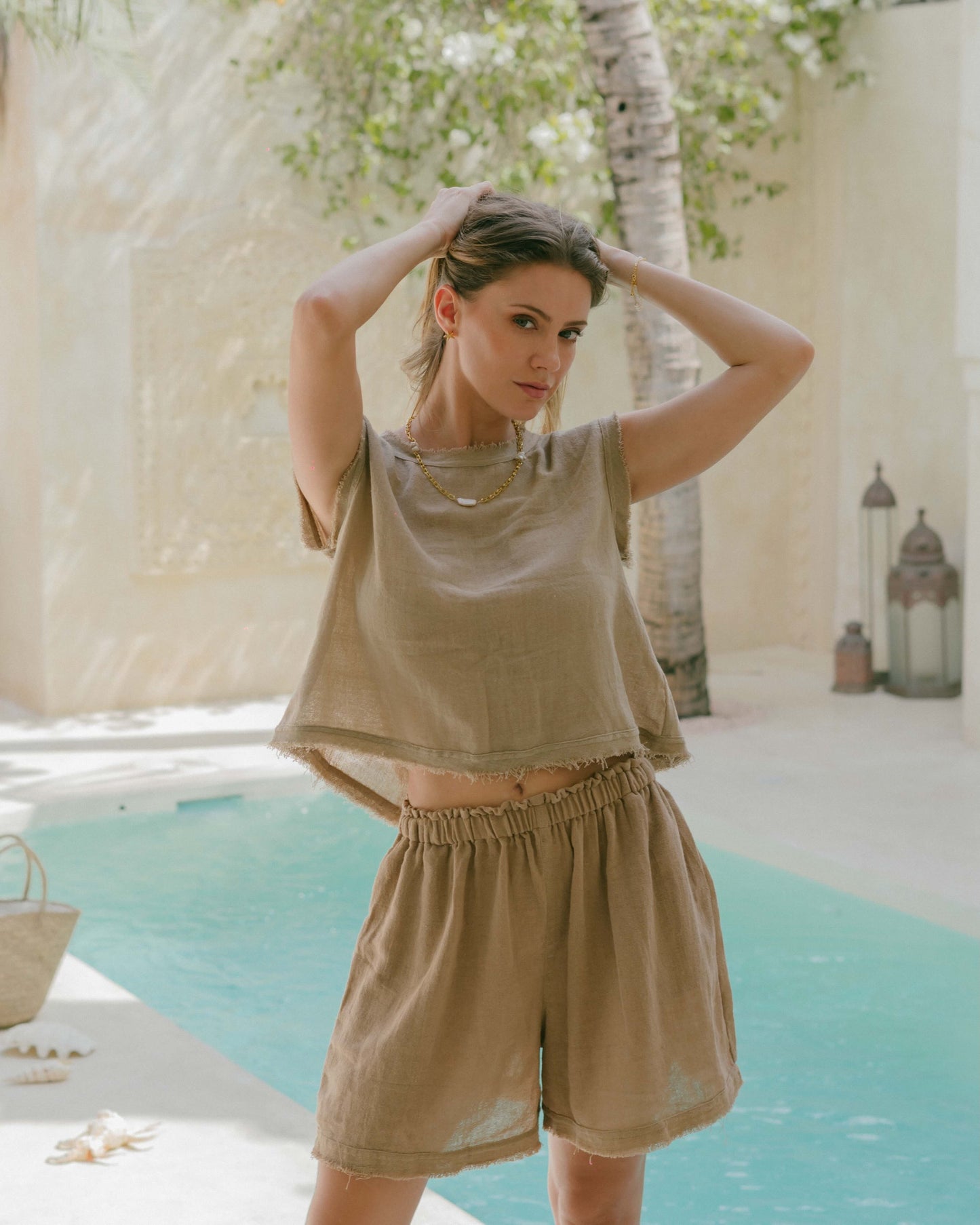 Reversible taupe tank top with frayed edges, tie-up front, and rounded neckline. A relaxed, versatile summer essential.