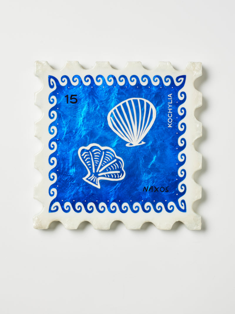 Decorative tile with shell design and blue watercolor pattern on a white background